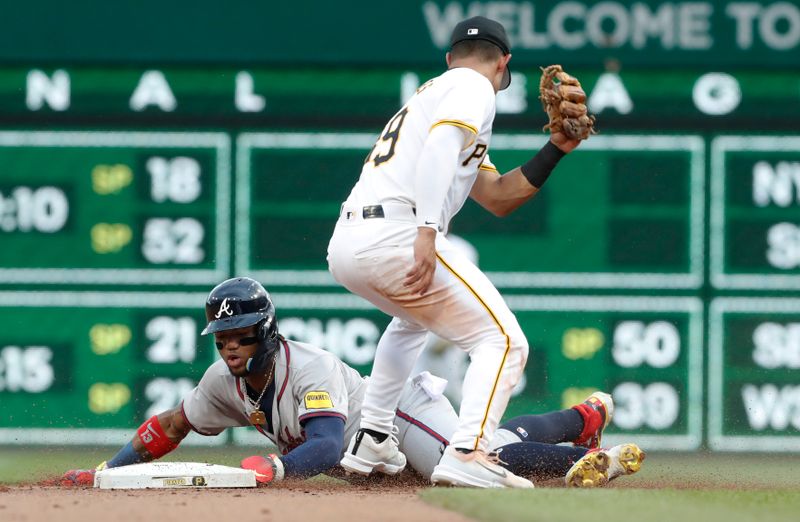 May 25, 2024; Pittsburgh, Pennsylvania, USA;  Atlanta Braves right fielder Ronald Acuña Jr. (13) steals second base as Pittsburgh Pirates second baseman Nick Gonzales (39) takes a late throw during the fifth inning at PNC Park. Mandatory Credit: Charles LeClaire-USA TODAY Sports