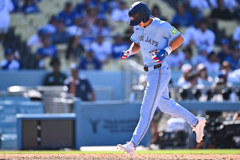 Aug 10, 2025; Los Angeles, California, USA; Toronto Blue Jays second baseman Ernie Clement (22) hits a solo home run against the Los Angeles Dodgers during the ninth inning at Dodger Stadium. Mandatory Credit: Jonathan Hui-Imagn Images