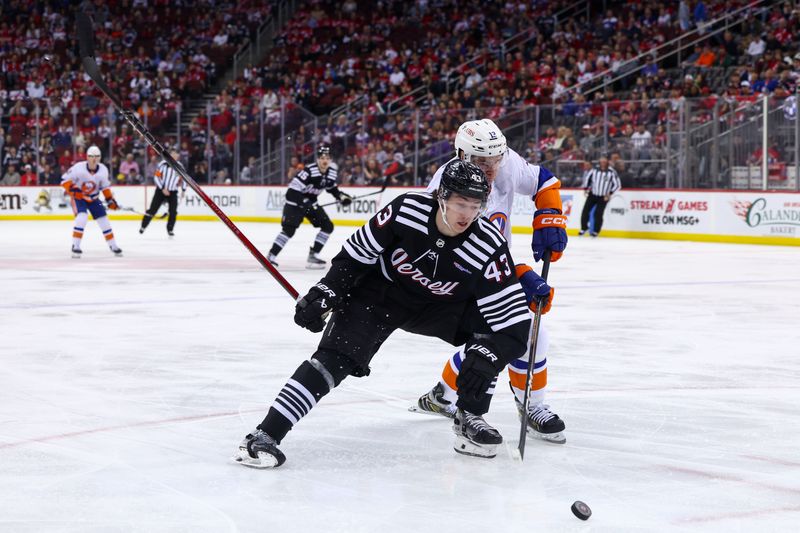 Apr 15, 2024; Newark, New Jersey, USA; New Jersey Devils defenseman Luke Hughes (43) and New York Islanders center Mathew Barzal (13) battle for the puck during the first period at Prudential Center. Mandatory Credit: Ed Mulholland-USA TODAY Sports