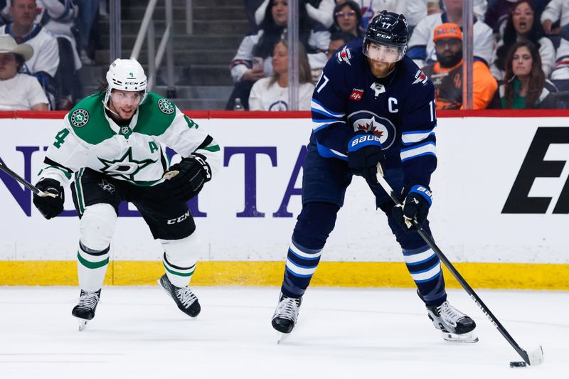 May 15, 2025; Winnipeg, Manitoba, CAN; Winnipeg Jets forward Adam Lowry (17) skates away from Dallas Stars defenseman Miro Heiskanen (4) during the second period in game five of the second round of the 2025 Stanley Cup Playoffs at Canada Life Centre. Mandatory Credit: Terrence Lee-Imagn Images