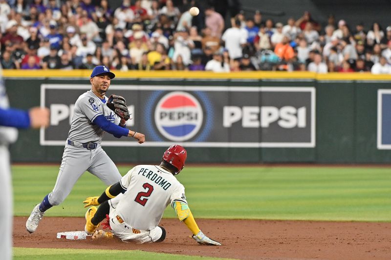 May 8, 2025; Phoenix, Arizona, USA; Arizona Diamondbacks shortstop Geraldo Perdomo (2) slides in front of Los Angeles Dodgers shortstop Mookie Betts (50) in the third inning at Chase Field. Mandatory Credit: Matt Kartozian-Imagn Images