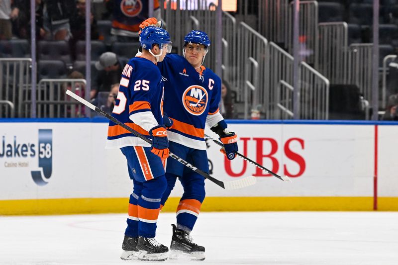 Oct 26, 2024; Elmont, New York, USA;  New York Islanders left wing Anders Lee (27) celebrates the goal by New York Islanders defenseman Dennis Cholowski (25) against the Florida Panthers during the first period at UBS Arena. Mandatory Credit: Dennis Schneidler-Imagn Images