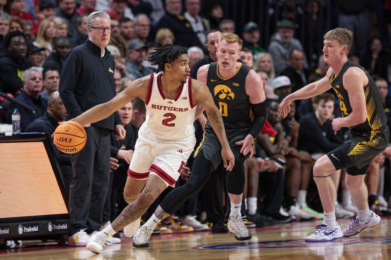 Feb 12, 2025; Piscataway, New Jersey, USA; Rutgers Scarlet Knights guard Dylan Harper (2) dribbles against Iowa Hawkeyes forward Even Brauns (0) during the first half at Jersey Mike's Arena. Mandatory Credit: Vincent Carchietta-Imagn Images