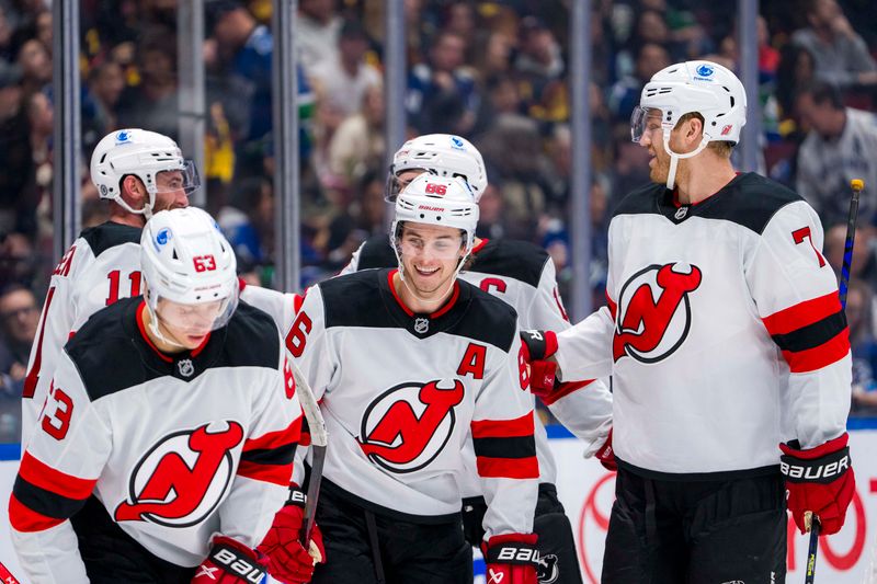 Oct 30, 2024; Vancouver, British Columbia, CAN; New Jersey Devils forward Jesper Bratt (63) and forward Stefan Noesen (11) and forward Jack Hughes (86) and forward Nico Hischier (13) celebrate Jack Hughes’ goal against the Vancouver Canucks during the third period at Rogers Arena. Mandatory Credit: Bob Frid-Imagn Images