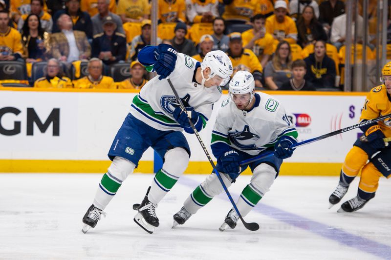 Apr 26, 2024; Nashville, Tennessee, USA; Vancouver Canucks right wing Ilya Mikheyev (65) and Vancouver Canucks left wing Nils Hoglander (21) chase after the puck against the Nashville Predators during the first period in game three of the first round of the 2024 Stanley Cup Playoffs at Bridgestone Arena. Mandatory Credit: Steve Roberts-USA TODAY Sports