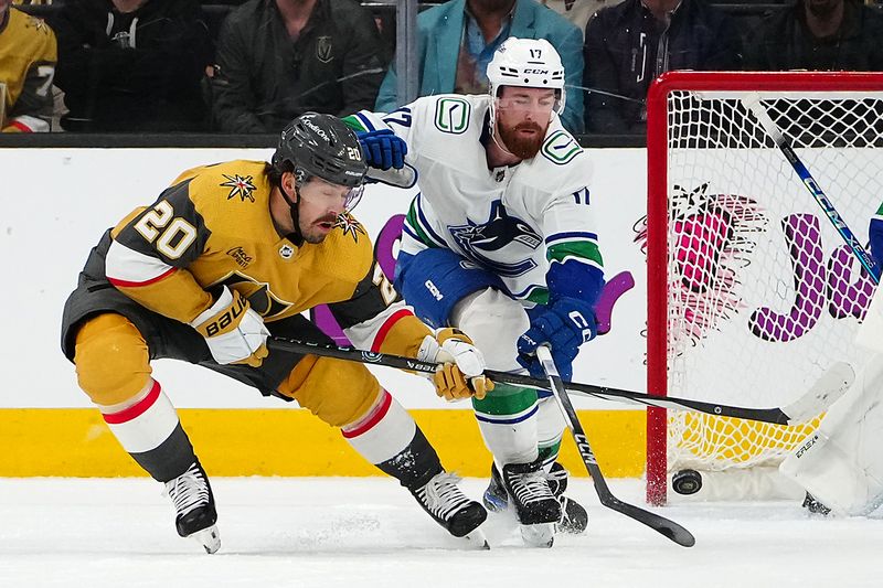 Mar 7, 2024; Las Vegas, Nevada, USA; Vancouver Canucks defenseman Filip Hronek (17) tips the puck away from Vegas Golden Knights center Chandler Stephenson (20) during the first period at T-Mobile Arena. Mandatory Credit: Stephen R. Sylvanie-USA TODAY Sports