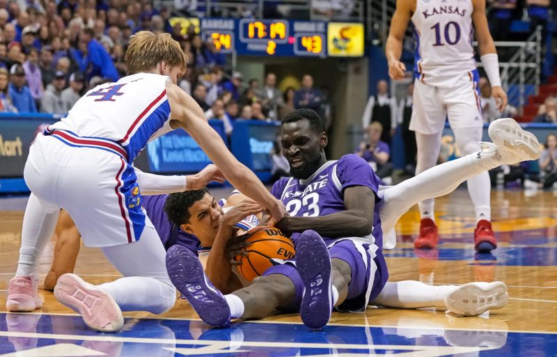 Jan 31, 2023; Lawrence, Kansas, USA; Kansas State Wildcats center Abayomi Iyiola (23) battles for a loose ball against Kansas Jayhawks guard Gradey Dick (4) and guard Kevin McCullar Jr. (15) during the second half at Allen Fieldhouse. Mandatory Credit: Jay Biggerstaff-USA TODAY Sports