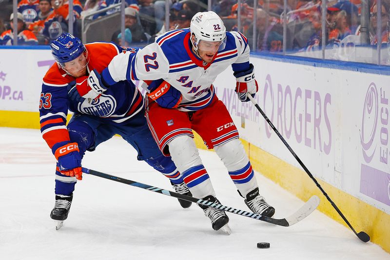 Nov 23, 2024; Edmonton, Alberta, CAN; New York Rangers forward Jonny Brodzinski (22) protects the puck from Edmonton Oilers forward Jeff Skinner (53) during the third period at Rogers Place. Mandatory Credit: Perry Nelson-Imagn Images