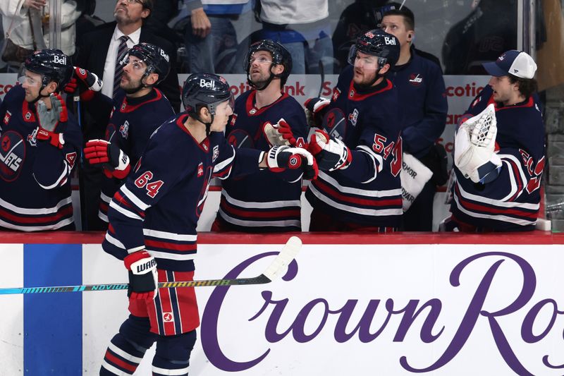 Dec 9, 2025; Winnipeg, Manitoba, CAN; Winnipeg Jets defenseman Logan Stanley (64) celebrates his goal against the Dallas Stars in the third period at Canada Life Centre. Mandatory Credit: James Carey Lauder-Imagn Images