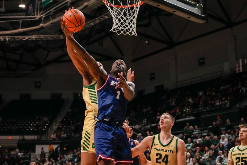 Jan 6, 2024; Charlotte, North Carolina, USA; Florida Atlantic Owls guard Johnell Davis (1) has his shot blocked by Charlotte 49ers center Dishon Jackson (1) during the second half at Dale F. Halton Arena. Mandatory Credit: Jim Dedmon-USA TODAY Sports