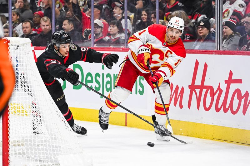 Nov 25, 2024; Ottawa, Ontario, CAN; Calgary Flames center Mikael Backlund (11) plays the puck near the net against the Ottawa Senators during the second period at Canadian Tire Centre. Mandatory Credit: David Kirouac-Imagn Images