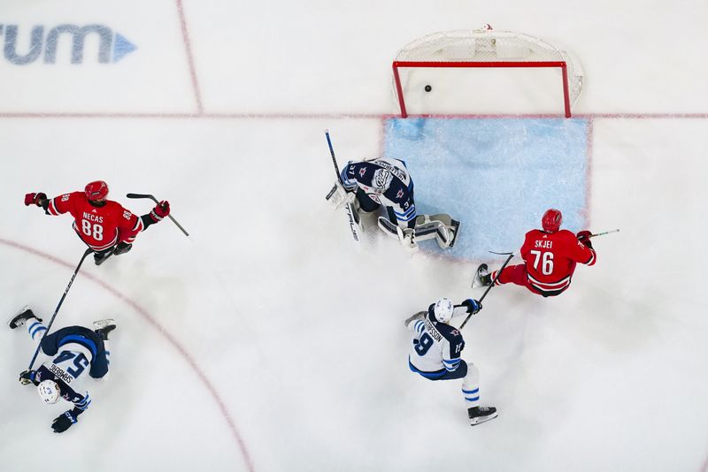 Mar 2, 2024; Raleigh, North Carolina, USA; Carolina Hurricanes center Martin Necas (88) scores a goal past Winnipeg Jets goaltender Connor Hellebuyck (37) during the second period at PNC Arena. Mandatory Credit: James Guillory-USA TODAY Sports