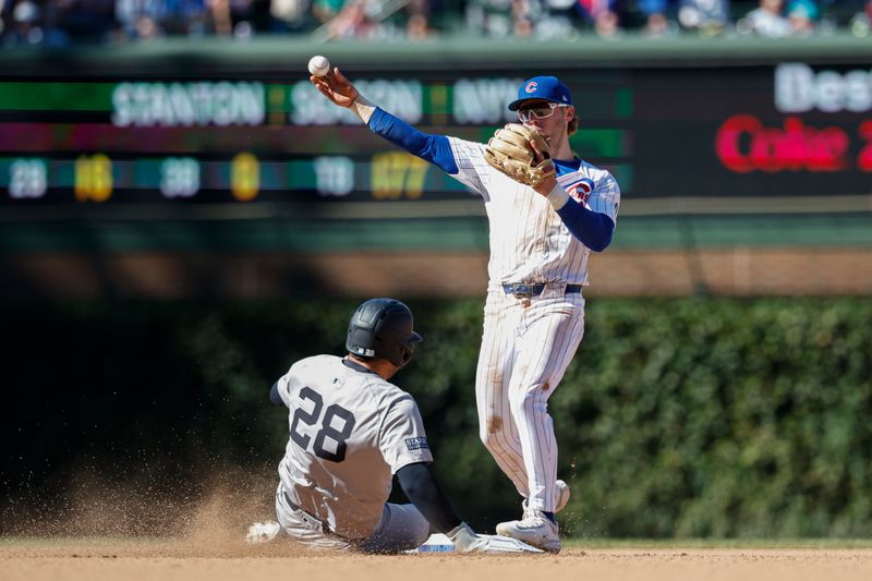 Sep 7, 2024; Chicago, Illinois, USA; Chicago Cubs second baseman Nico Hoerner (2) throws out New York Yankees catcher Austin Wells (28) at second base during the eight inning at Wrigley Field. Mandatory Credit: Kamil Krzaczynski-Imagn Images