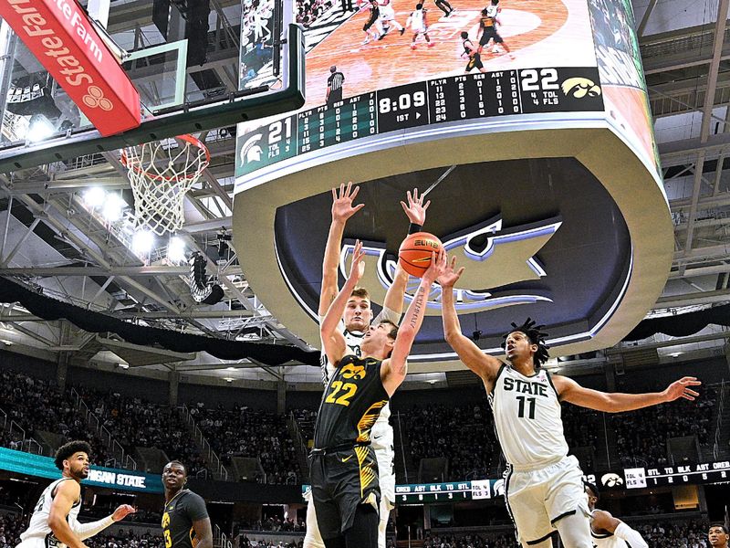 Feb 20, 2024; East Lansing, Michigan, USA;  Iowa Hawkeyes forward Patrick McCaffery (22) drives past the Michigan State Spartans defense during the first half at Jack Breslin Student Events Center. Mandatory Credit: Dale Young-USA TODAY Sports
