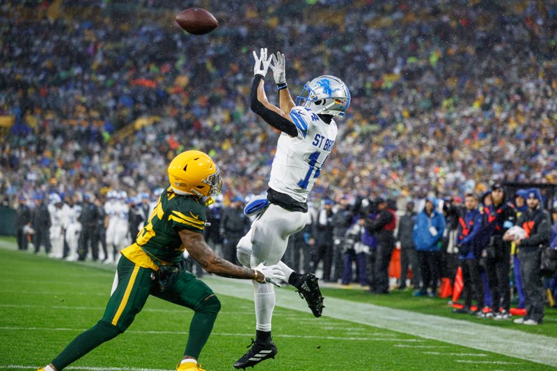 Detroit Lions wide receiver Amon-Ra St. Brown (14) catches a touchdown against Green Bay Packers cornerback Keisean Nixon (25) during the first half of an NFL football game Sunday, Nov. 3, 2024, in Green Bay, Wis. (AP Photo/Jeffrey Phelps