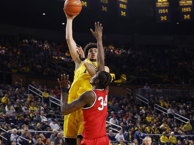 Jan 15, 2024; Ann Arbor, Michigan, USA; Michigan Wolverines forward Olivier Nkamhoua (13) shoots over Ohio State Buckeyes center Felix Okpara (34) in the first half at Crisler Center. Mandatory Credit: Rick Osentoski-USA TODAY Sports