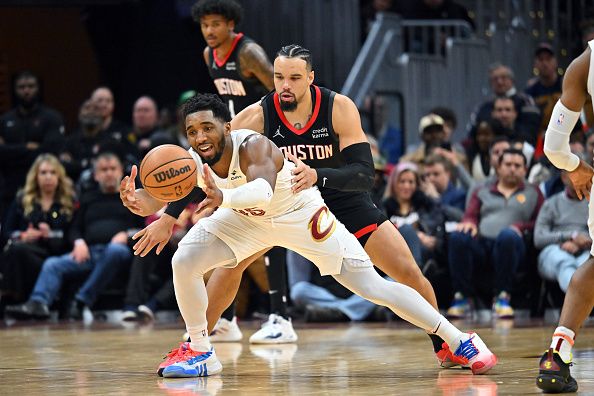 CLEVELAND, OHIO - DECEMBER 18: Donovan Mitchell #45 of the Cleveland Cavaliers grabs a loose ball while under pressure from Fred VanVleet #5 of the Houston Rockets during the fourth quarter at Rocket Mortgage Fieldhouse on December 18, 2023 in Cleveland, Ohio. The Cavaliers defeated the Rockets 135-130 in overtime. NOTE TO USER: User expressly acknowledges and agrees that, by downloading and or using this photograph, User is consenting to the terms and conditions of the Getty Images License Agreement. (Photo by Jason Miller/Getty Images)