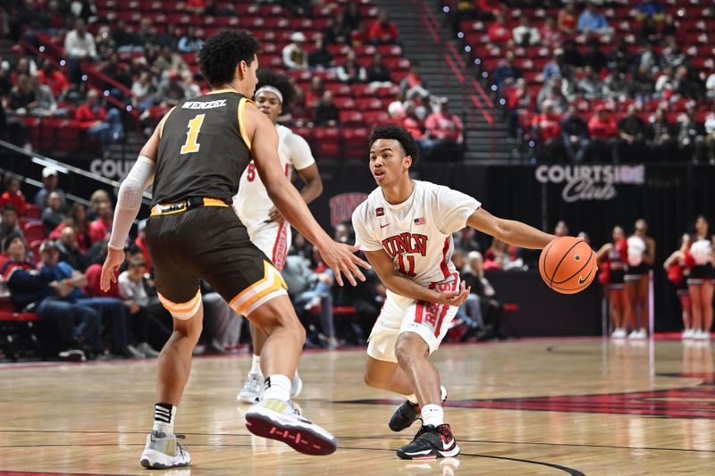 Feb 3, 2024; Las Vegas, Nevada, USA; UNLV Rebels guard Dedan Thomas Jr. (11) tries to pass the ball past Wyoming Cowboys guard Brendan Wenzel (1) in the first half at Thomas & Mack Center. Mandatory Credit: Candice Ward-USA TODAY Sports