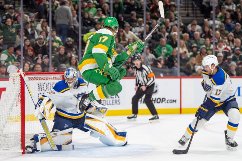 Mar 15, 2025; Saint Paul, Minnesota, USA; Minnesota Wild left wing Marcus Foligno (17) jumps out of the way of a shot by defenseman Jake Middleton (5) which scored on St. Louis Blues goaltender Joel Hofer (30) in the second period at Xcel Energy Center. Mandatory Credit: Matt Blewett-Imagn Images