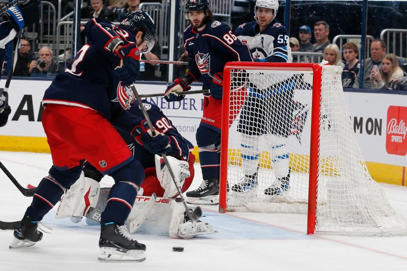 Mar 17, 2024; Columbus, Ohio, USA; Columbus Blue Jackets center Alexander Texier (42) sweeps away the round of a goalie Elvis Merzlikins (90) save against the Winnipeg Jets during the third period at Nationwide Arena. Mandatory Credit: Russell LaBounty-USA TODAY Sports