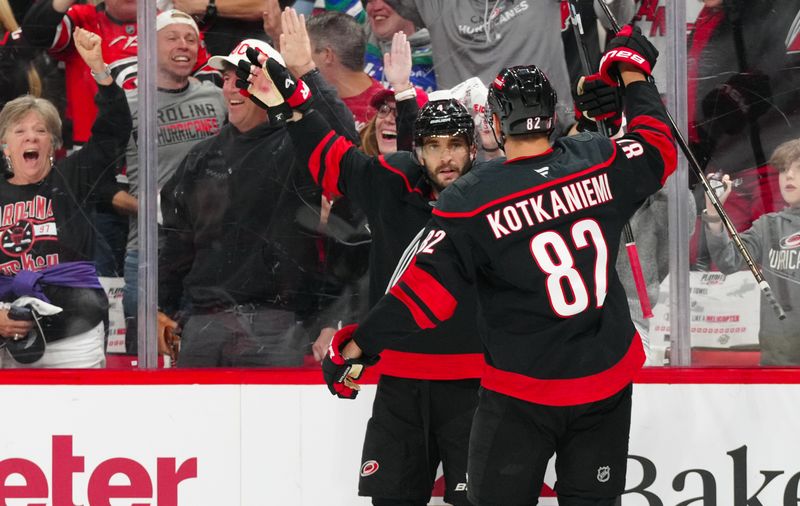 May 12, 2025; Raleigh, North Carolina, USA; Carolina Hurricanes defenseman Shayne Gostisbehere (4) celebrates his goal with center Jesperi Kotkaniemi (82) against the Washington Capitals during the first period in game four of the second round of the 2025 Stanley Cup Playoffs at Lenovo Center. Mandatory Credit: James Guillory-Imagn Images