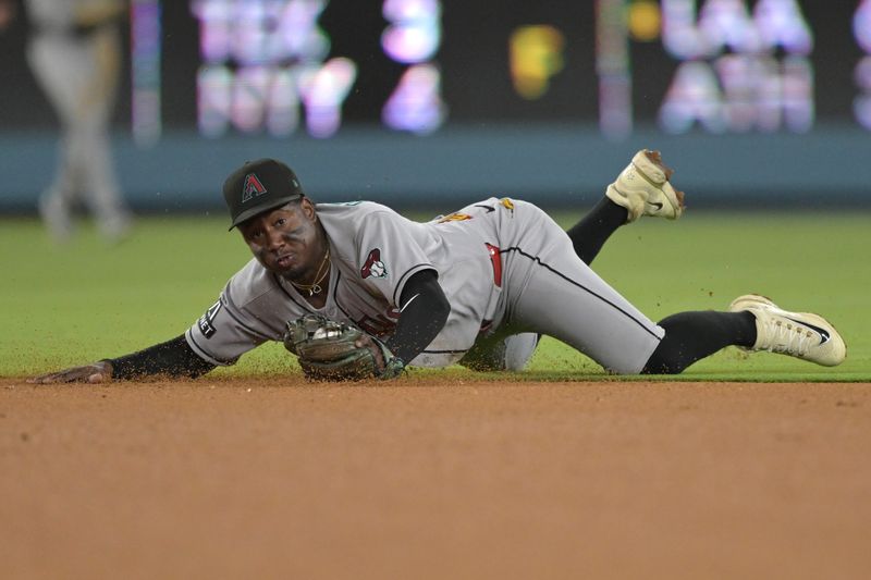 May 21, 2025; Los Angeles, California, USA; Arizona Diamondbacks shortstop Geraldo Perdomo (2) makes a stop on a ball hit by Los Angeles Dodgers second baseman Miguel Rojas (72) but has not play in the sixth inning at Dodger Stadium. Mandatory Credit: Jayne Kamin-Oncea-Imagn Images
