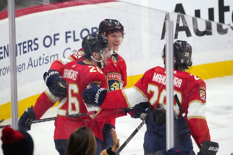 Nov 10, 2023; Sunrise, Florida, USA; Florida Panthers defenseman Uvis Balinskis (26) celebrates with teammates after scoring a goal against the Carolina Hurricanes during the first period at Amerant Bank Arena. Mandatory Credit: Jasen Vinlove-USA TODAY Sports