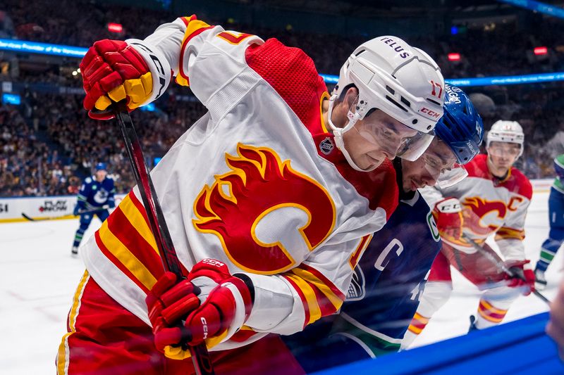 Apr 16, 2024; Vancouver, British Columbia, CAN; Calgary Flames forward Yegor Sharangovich (17) battles with Vancouver Canucks defenseman Quinn Hughes (43) in the second period at Rogers Arena. Mandatory Credit: Bob Frid-USA TODAY Sports