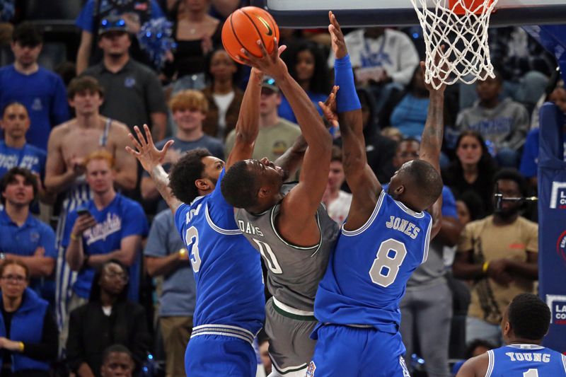 Mar 3, 2024; Memphis, Tennessee, USA; UAB Blazers forward Javian Davis (0) shoots between Memphis Tigers center Jordan Brown (3) and forward David Jones (8) during the first half at FedExForum. Mandatory Credit: Petre Thomas-USA TODAY Sports