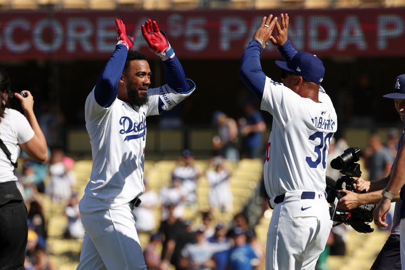 Aug 11, 2024; Los Angeles, California, USA;  Los Angeles Dodgers left fielder Teoscar Hernandez (37) celebrates with manager Dave Roberts (30) after hitting a game winning RBI single in bottom of the tenth inning against the Pittsburgh Pirates at Dodger Stadium. Mandatory Credit: Kiyoshi Mio-USA TODAY Sports