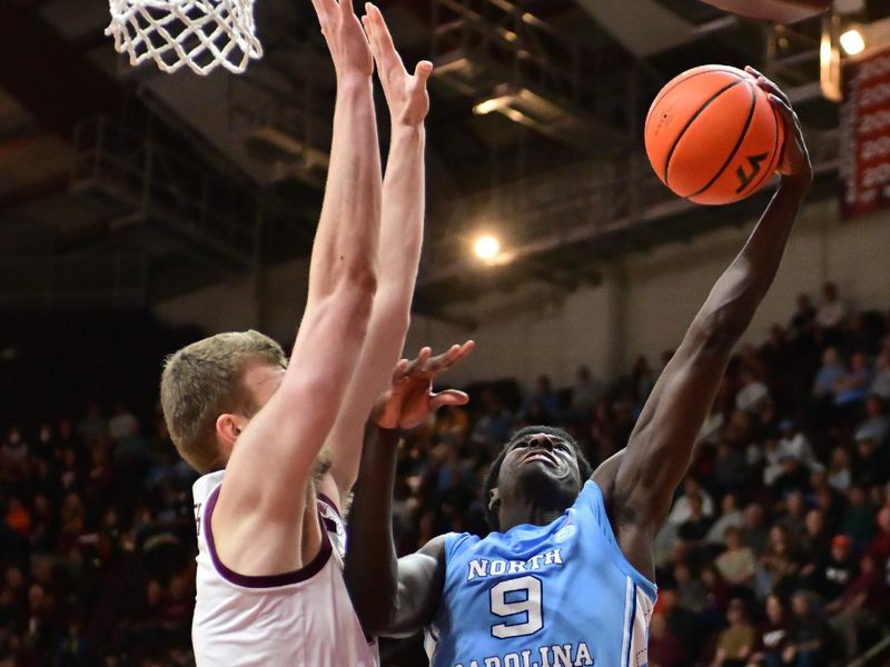 Mar 4, 2025; Blacksburg, Virginia, USA;  North Carolina Tar Heels guard Drake Powell (9) makes a move toward the basket as Virginia Tech Hokies center Patrick Wessler (5) defends during the second half at Cassell Coliseum. Mandatory Credit: Brian Bishop-Imagn Images