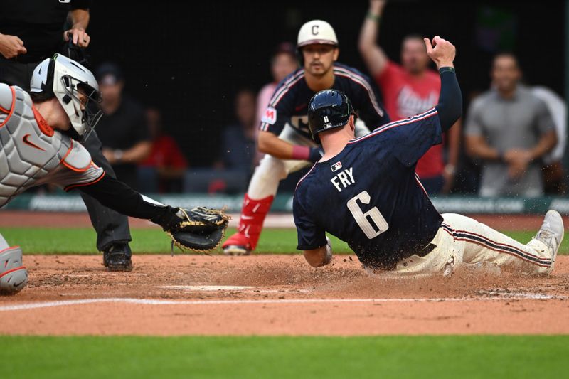 Aug 2, 2024; Cleveland, Ohio, USA; Cleveland Guardians designated hitter David Fry (6) scores past the tag of Baltimore Orioles catcher Adley Rutschman (35) during the second inning at Progressive Field. Mandatory Credit: Ken Blaze-USA TODAY Sports