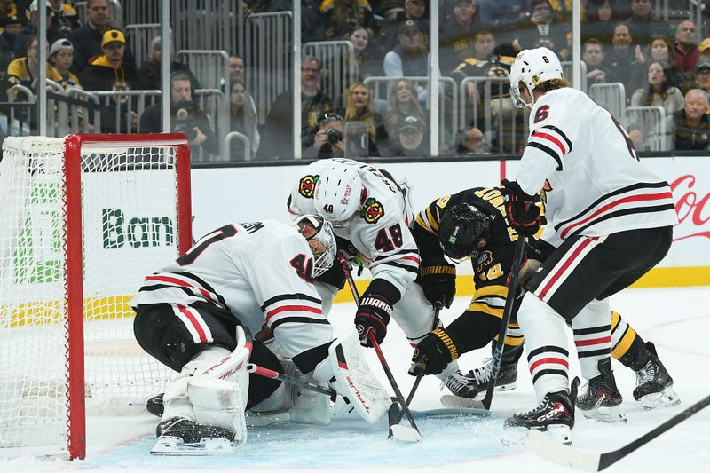 Oct 9, 2025; Boston, Massachusetts, USA; Boston Bruins left wing Tanner Jeannot (84) Chicago Blackhawks defenseman Matt Grzelcyk (48) defenseman Sam Rinzel (6) battle for the puck in front of goaltender Arvid Soderblom (40) during the third period at TD Garden. Mandatory Credit: Bob DeChiara-Imagn Images