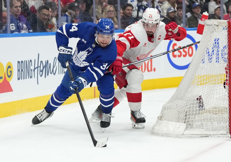 Apr 13, 2024; Toronto, Ontario, CAN; Toronto Maple Leafs center Auston Matthews (34) battles for the puck behind the net with Detroit Red Wings center Dylan Larkin (71) during the third period at Scotiabank Arena. Mandatory Credit: Nick Turchiaro-USA TODAY Sports