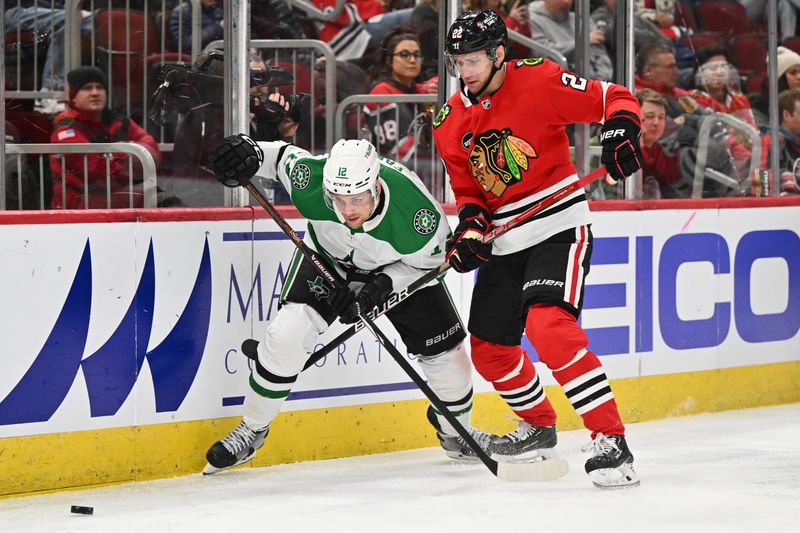 Jan 13, 2024; Chicago, Illinois, USA;  Dallas Stars forward Radek Faksa (12) and Chicago Blackhawks defenseman Nikita Zaitsev (22) battle for control of the puck along the boards in the second period at United Center. Mandatory Credit: Jamie Sabau-USA TODAY Sports