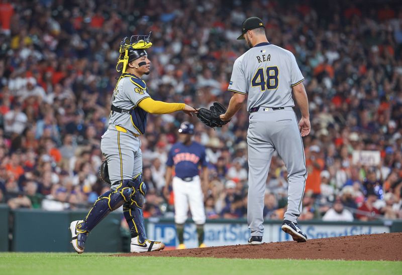 May 19, 2024; Houston, Texas, USA; Milwaukee Brewers catcher William Contreras (24) hands the ball to starting pitcher Colin Rea (48) during a mound visit in the first inning against the Houston Astros at Minute Maid Park. Mandatory Credit: Troy Taormina-USA TODAY Sports