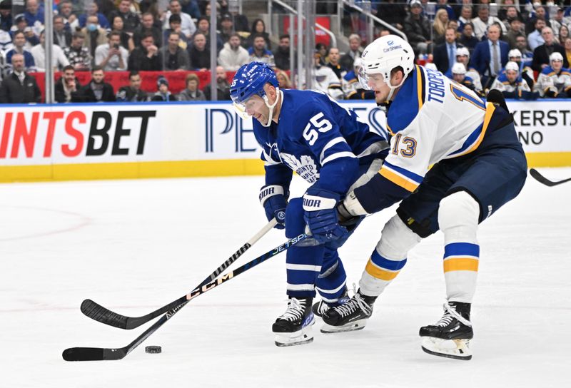 Jan 3, 2023; Toronto, Ontario, CAN; Toronto Maple Leafs defenseman Mark Giordano (55) battles for the puck with St. Louis Blues forward Alexey Toropchenko (13) in the second period at Scotiabank Arena. Mandatory Credit: Dan Hamilton-USA TODAY Sports