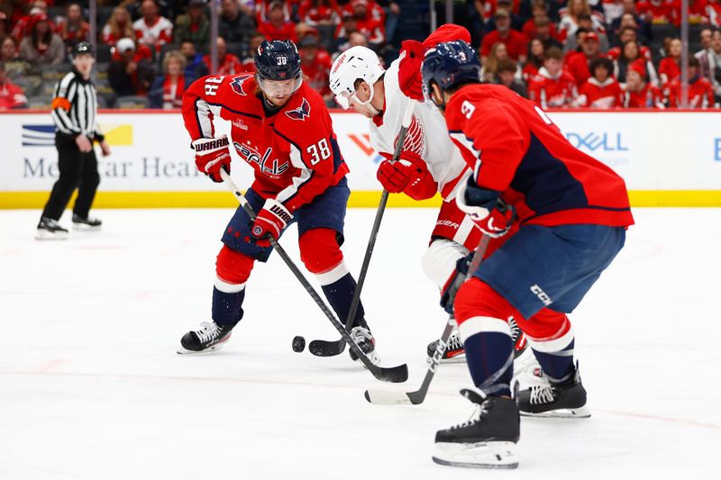 Mar 26, 2024; Washington, District of Columbia, USA; Washington Capitals defenseman Rasmus Sandin (38) battles for the puck with Detroit Red Wings left wing Lucas Raymond (23) during the second period at Capital One Arena. Mandatory Credit: Amber Searls-USA TODAY Sports