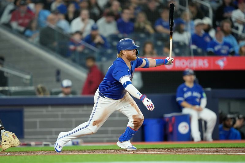 Apr 14, 2024; Toronto, Ontario, CAN; Toronto Blue Jays designated hitter Justin Turner (2) hits a one run single against the Colorado Rockies during the fifth inning at Rogers Centre. Mandatory Credit: John E. Sokolowski-USA TODAY Sports