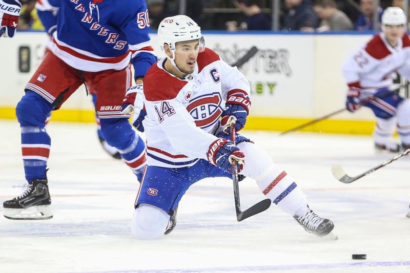 Feb 15, 2024; New York, New York, USA; Montreal Canadiens center Nick Suzuki (14) passes the puck in the second period against the New York Rangers at Madison Square Garden. Mandatory Credit: Wendell Cruz-USA TODAY Sports