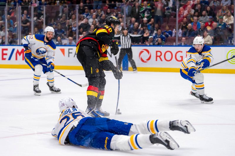 Mar 19, 2024; Vancouver, British Columbia, CAN; Buffalo Sabres defenseman Bowen Byram (4) watches as Vancouver Canucks forward Elias Pettersson (40) scores his second goal of the game in the third period at Rogers Arena. Vancouver won 3 -2. Mandatory Credit: Bob Frid-USA TODAY Sports