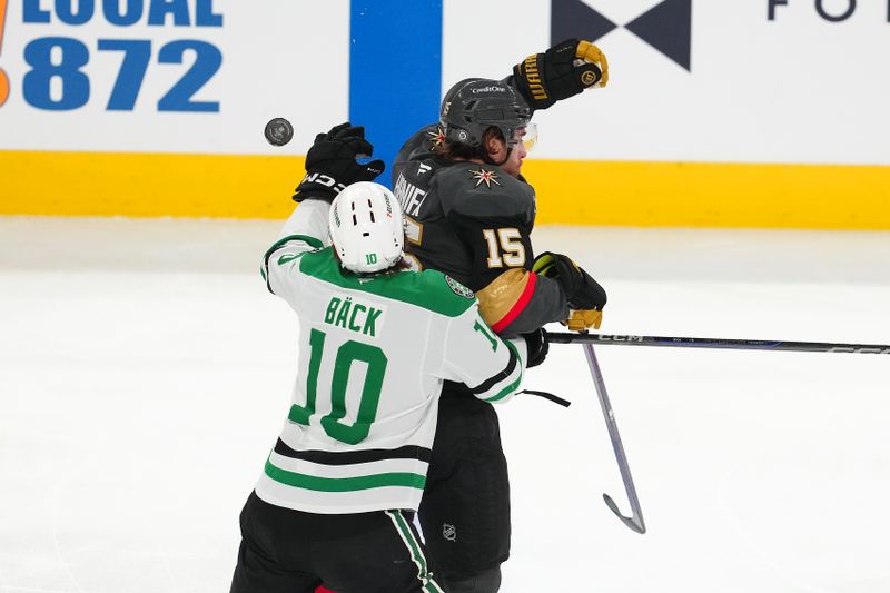 Jan 28, 2025; Las Vegas, Nevada, USA; Vegas Golden Knights defenseman Noah Hanifin (15) and Dallas Stars center Oskar Bäck (10) reach for the puck during the third period at T-Mobile Arena. Mandatory Credit: Stephen R. Sylvanie-Imagn Images