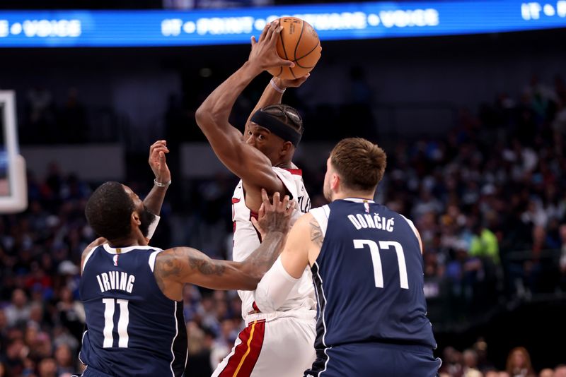 DALLAS, TEXAS - MARCH 07: Jimmy Butler #22 of the Miami Heat looks to pass the ball while defended by Kyrie Irving #11 and Luka Doncic #77 of the Dallas Mavericks in the first half at American Airlines Center on March 07, 2024 in Dallas, Texas.  NOTE TO USER: User expressly acknowledges and agrees that, by downloading and or using this photograph, User is consenting to the terms and conditions of the Getty Images License Agreement. (Photo by Tim Heitman/Getty Images)