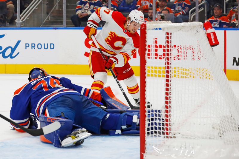 Oct 13, 2024; Edmonton, Alberta, CAN; Edmonton Oilers goaltender Stuart Skinner (74) makes a save on on Calgary Flames forward Connor Zary (47) during the second period at Rogers Place. Mandatory Credit: Perry Nelson-Imagn Images