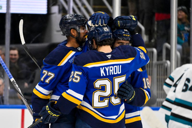 Nov 21, 2024; St. Louis, Missouri, USA;  St. Louis Blues center Jordan Kyrou (25) is congratulated by center Robert Thomas (18) and defenseman Pierre-Olivier Joseph (77) after scoring against the San Jose Sharks during the second period at Enterprise Center. Mandatory Credit: Jeff Curry-Imagn Images