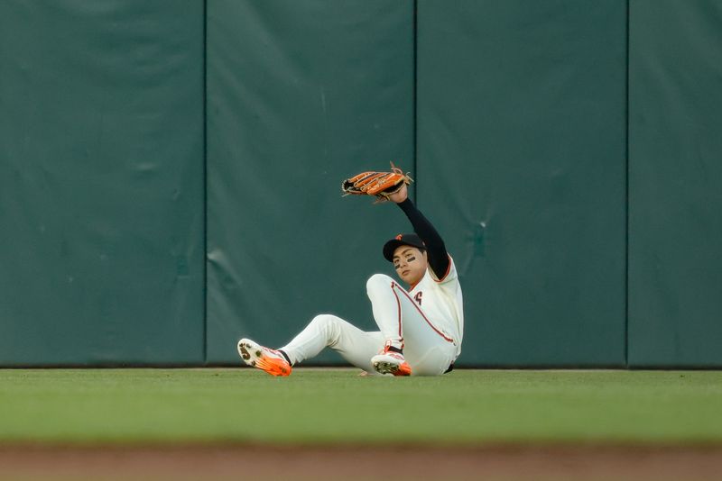 May 19, 2025; San Francisco, California, USA; San Francisco Giants center fielder Jung Hoo Lee (51) slides to make a catch during the fifth inning against the Kansas City Royals at Oracle Park. Mandatory Credit: Sergio Estrada-Imagn Images