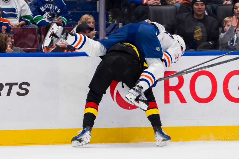 Nov 6, 2023; Vancouver, British Columbia, CAN; Edmonton Oilers forward Warren Foegele (37) hits Vancouver Canucks forward Elias Pettersson (40) in the third period at Rogers Arena. Vancouver won 6-2. Mandatory Credit: Bob Frid-USA TODAY Sports