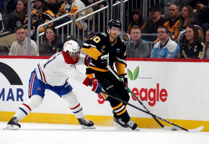 Feb 22, 2024; Pittsburgh, Pennsylvania, USA; Pittsburgh Penguins center Lars Eller (20) moves the puck against Montreal Canadiens defenseman Kaiden Guhle (21) during the second period at PPG Paints Arena.  The Penguins won 4-1. Mandatory Credit: Charles LeClaire-USA TODAY Sports