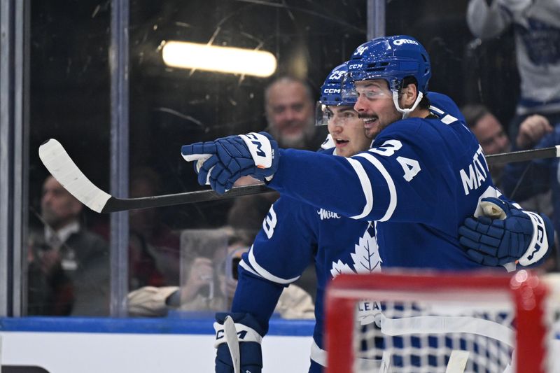 Oct 14, 2025; Toronto, Ontario, CAN;  Toronto Maple Leafs forward Auston Matthews (34) celebrates with forward Matthews Knies (23) after scoring a goal against the Nashville Predators in the third period at Scotiabank Arena. Mandatory Credit: Dan Hamilton-Imagn Images