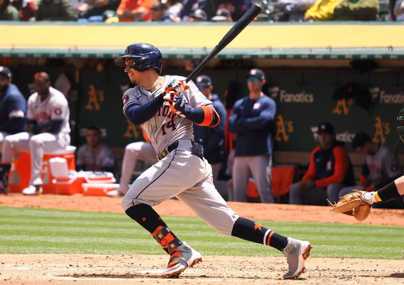 May 25, 2024; Oakland, California, USA; Houston Astros second baseman Mauricio Dubon (14) hits a single Oakland Athletics during the third inning at Oakland-Alameda County Coliseum. Mandatory Credit: Kelley L Cox-USA TODAY Sports